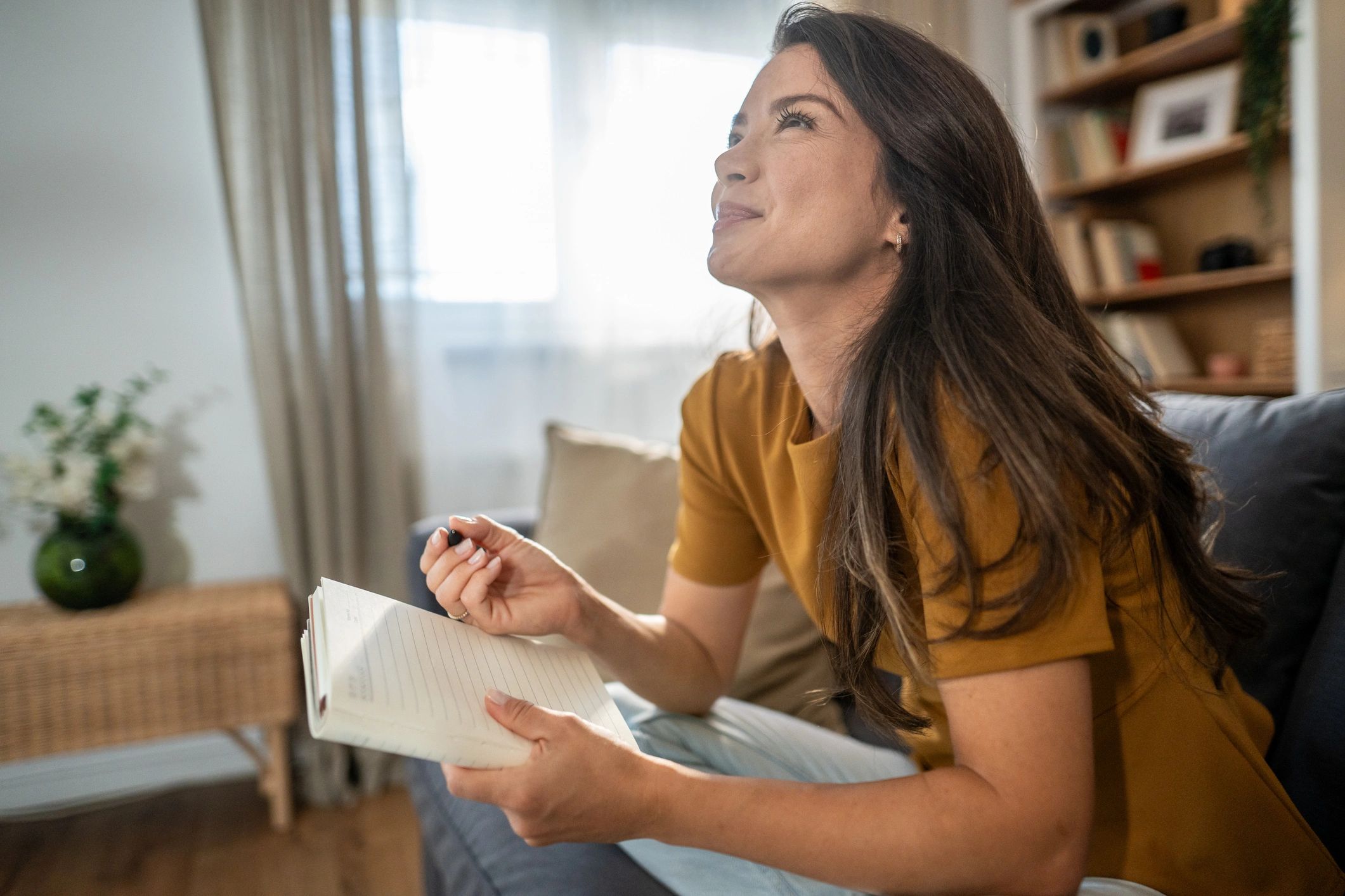 Woman journaling thoughtfully at home